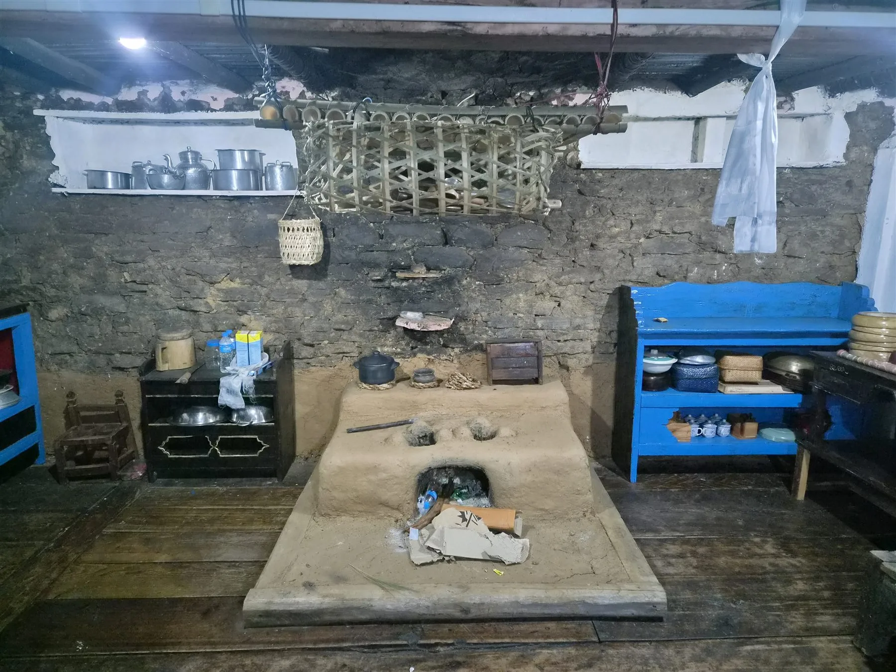 Traditional clay and mud hearth with black cooking pots in Dun Kitchen