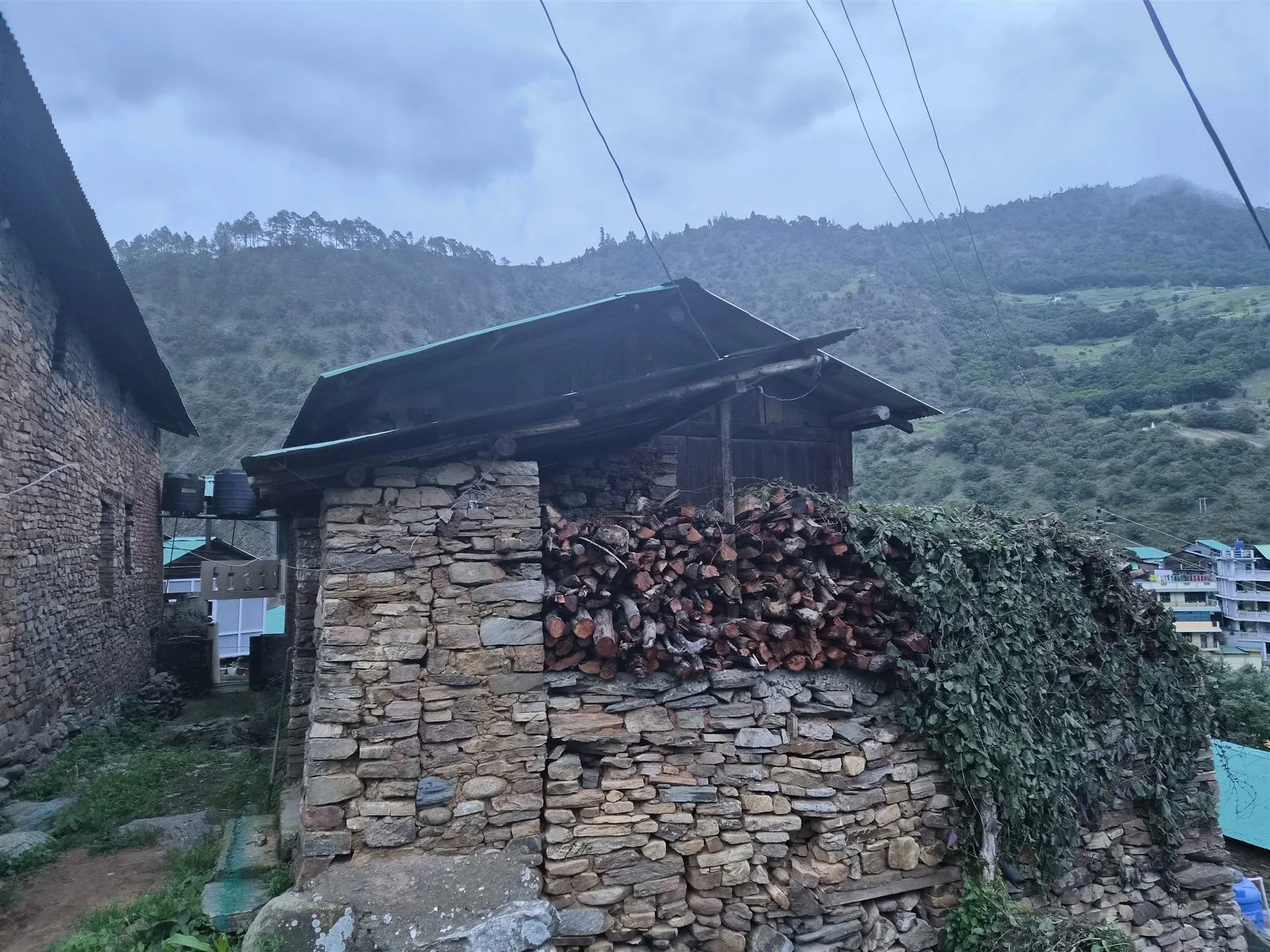 Firewood stacked against an old stone house