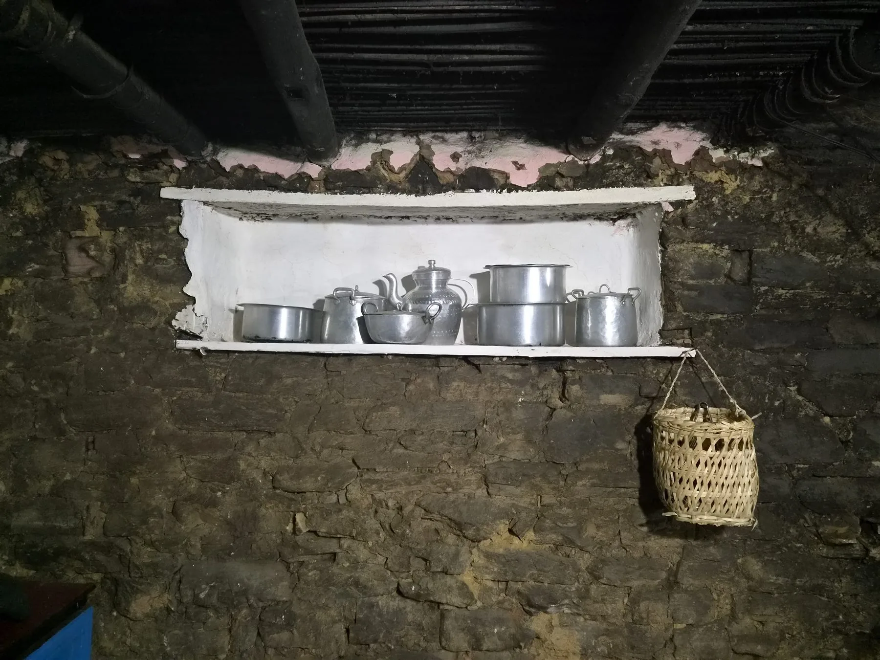 Metal vessels in a traditional stone kitchen niche